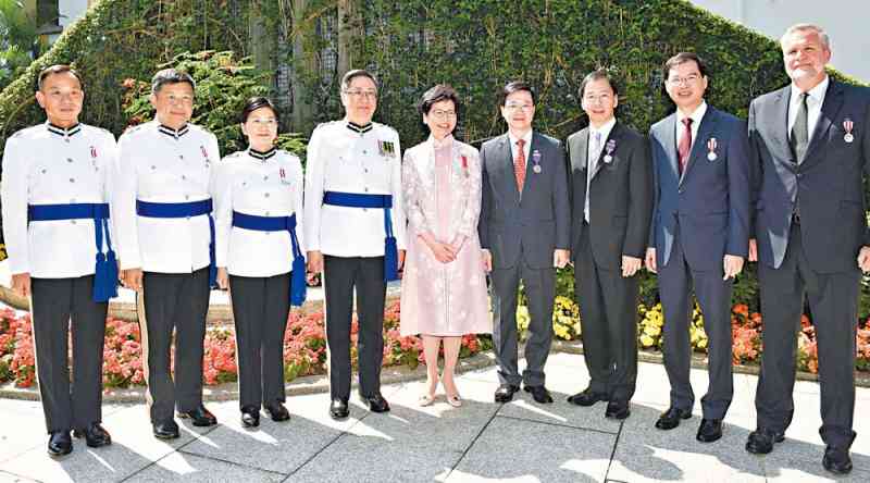 行政长官林郑月娥（中）、保安局局长李家超（右四）和处长卢伟聪（右六）与获颁奖章人员合照。