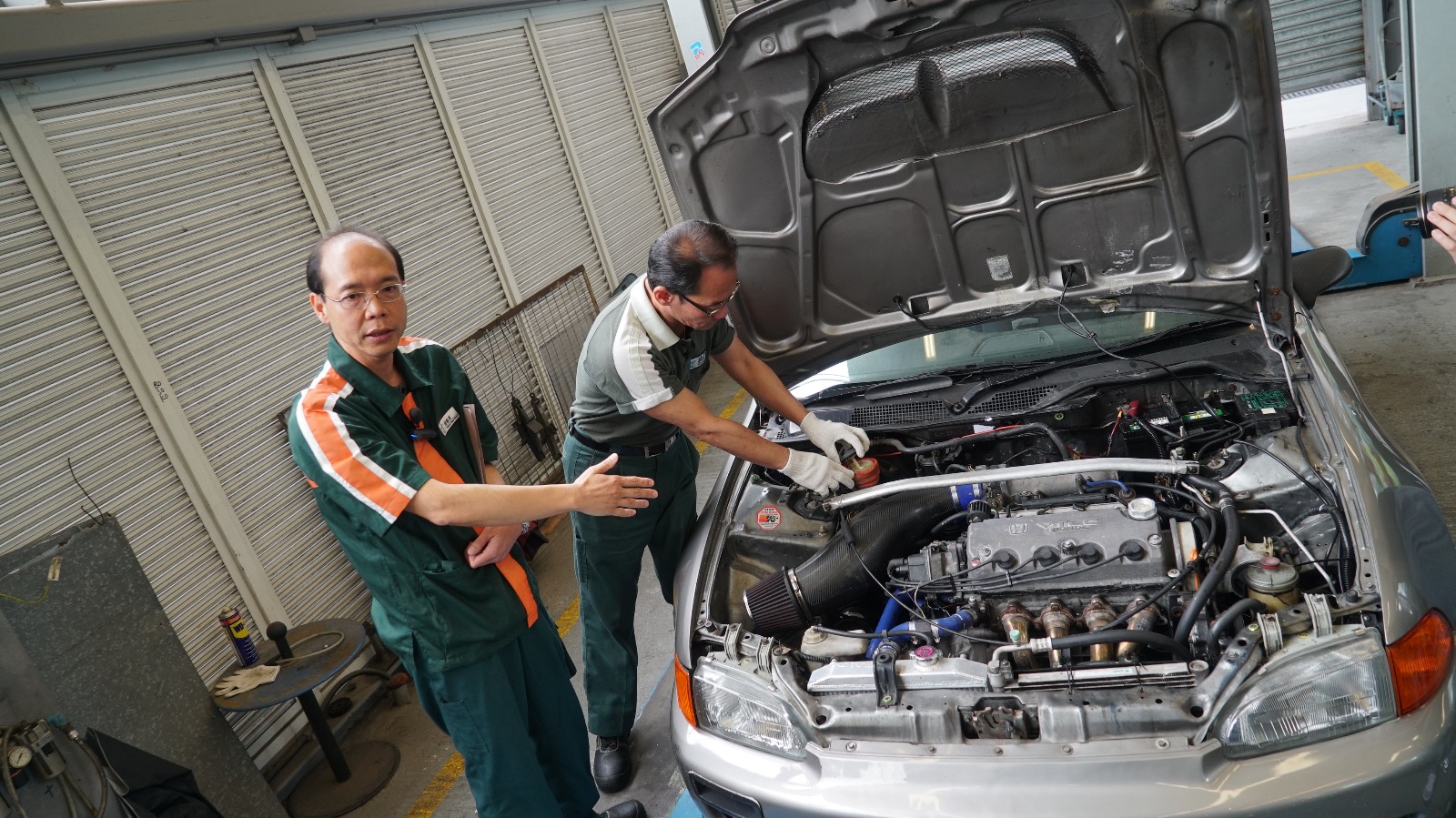 運輸署一級驗車主任龍沛華（左）解釋檢驗改裝車輛的程序。