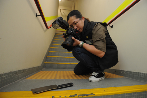 Photograph:Police officer of Identification Bureau taking photograph of exhibit for record