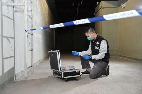 Photograph: Police officer of Identification Bureau collecting DNA sample