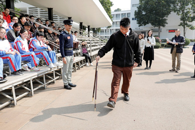 A student tries to use pace stick to measure his pace.