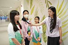 譚樂陶(左一)與「深圳香港培僑信義書院龍華信義學校」的學生交流