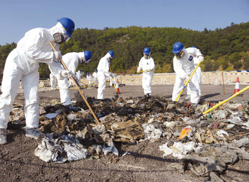 Police Tactical Unit officers mount a search operation at a landfill site in a case that involves preventing the lawful burial of a body.