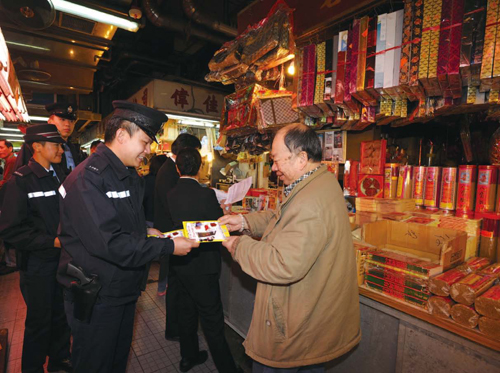 Police officers distribute anticrime
leaflets to shops.