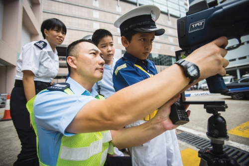 東九龍交通部人員向到訪行動基地的少數族裔學生介紹鐳射測速儀。