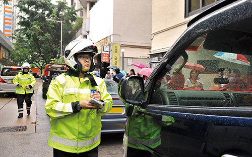 Traffic Police officers taking enforcement action against drivers obstructing traffic flow.