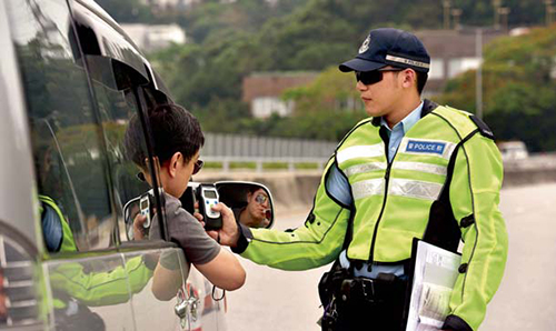 A police officer asking a driver to take a breathalyser test. 