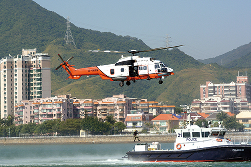 Officers of the Government Flying Service lift an injured person from a Marine Police vessel during a joint exercise.