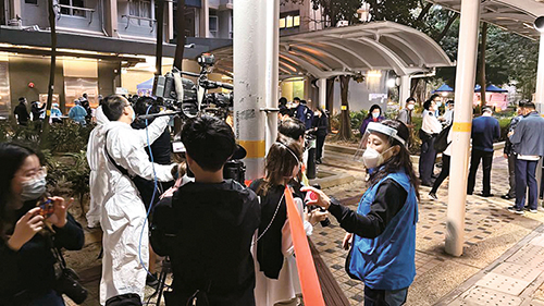 警察傳媒聯絡隊成員在圍封強檢現場幫助前線人員協調傳媒採訪。
