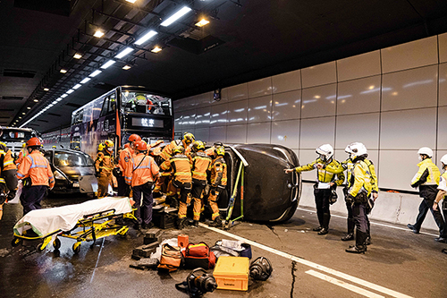 東九龍總區交通部人員與消防處及聖約翰救傷隊人員進行將軍澳藍田隧道跨部門演習，模擬拯救被困司機。