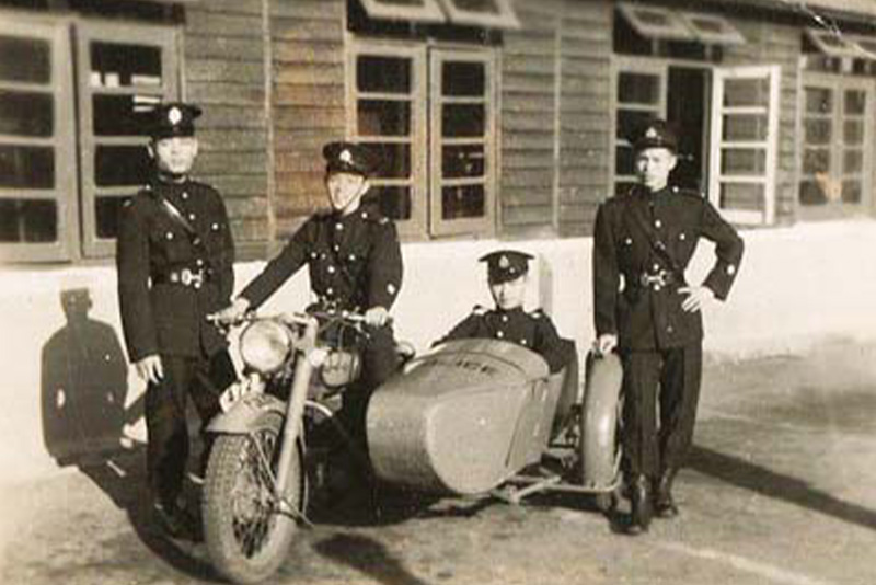 Officers sat on a motorcycle with a sidecar, the 1950s.