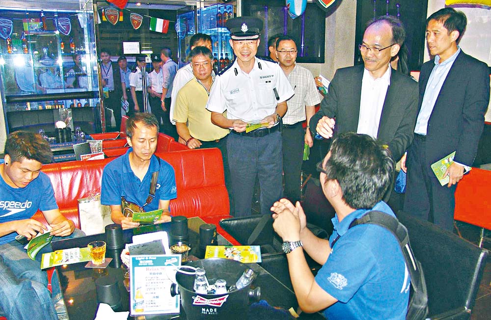 譚澤恆（中）、郭振華（右二）及滅罪委員會會員在深水埗區酒吧向巿民派發宣傳單張。