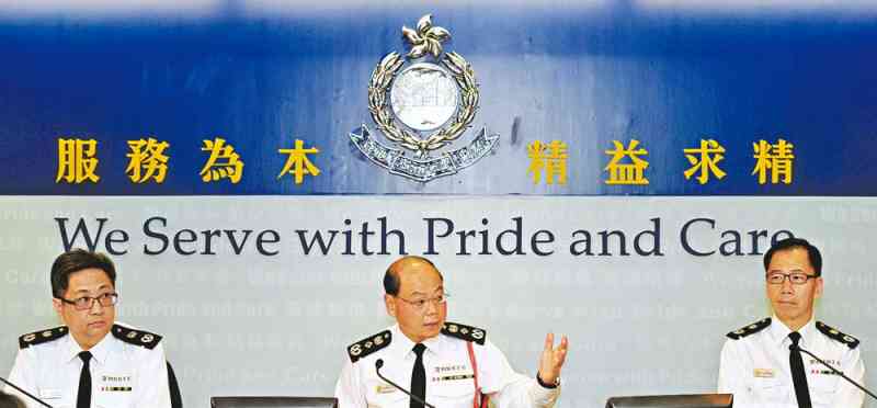 Mr Tsang, flanked by Deputy Commissioner (Management) Lo Wai-chung (left) and Deputy Commissioner (Operations) Wong Chi-hung, reviews the crime situation in 2014