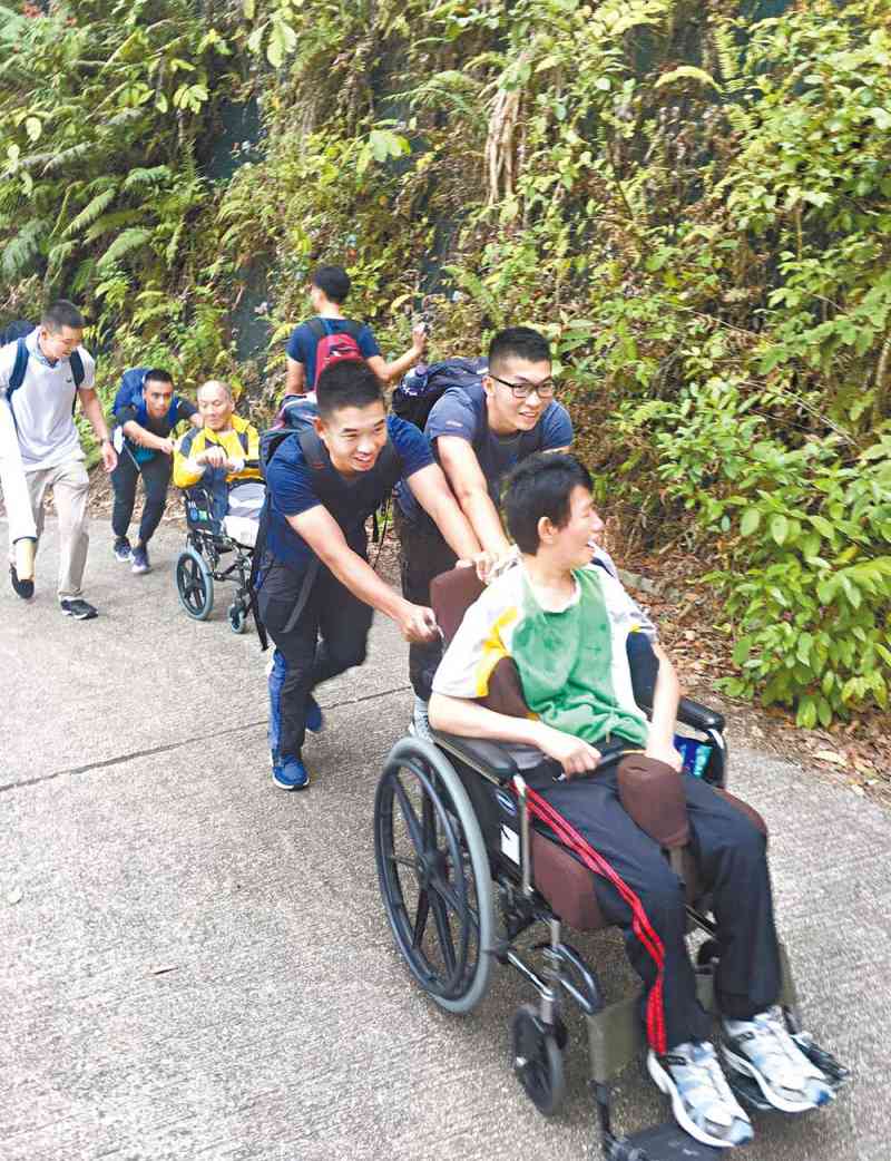 学警协助轮椅使用者上山欣赏美景。