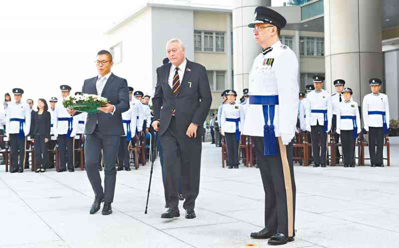 A representative of the Royal Hong Kong Police Association (centre) is going to lay a wreath, with Mr Lo (right) looking on