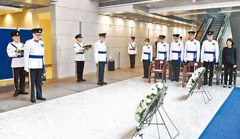 Commissioner Lo Wai-chung (second left) and attendees observe a silence in memory of all those who have fallen in the line of duty