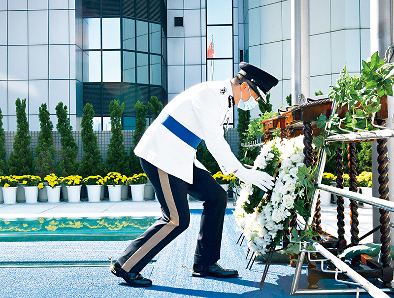 處長鄧炳強於刻有殉職人員姓名的紀念冊前獻上花圈。