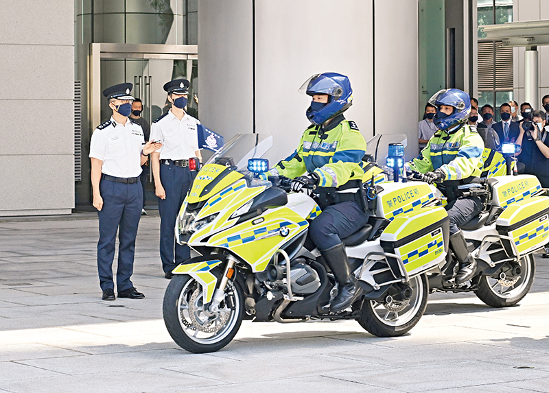 处长萧泽颐（左一）于警察总部主持新旧电单车交接仪式，宣布新一代电单车正式投入服务。