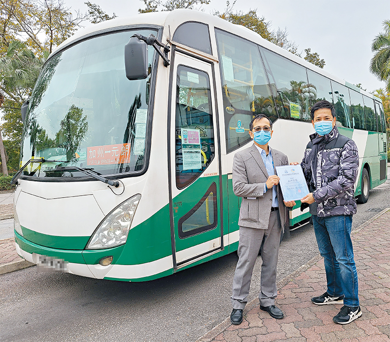 An officer (right) thanks a private housing estate’s representative for displaying anti-deception information on shuttle buses.