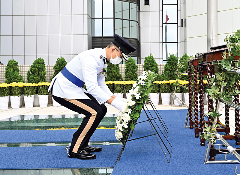 处长萧泽颐于刻有殉职人员姓名的纪念册前献上花圈。